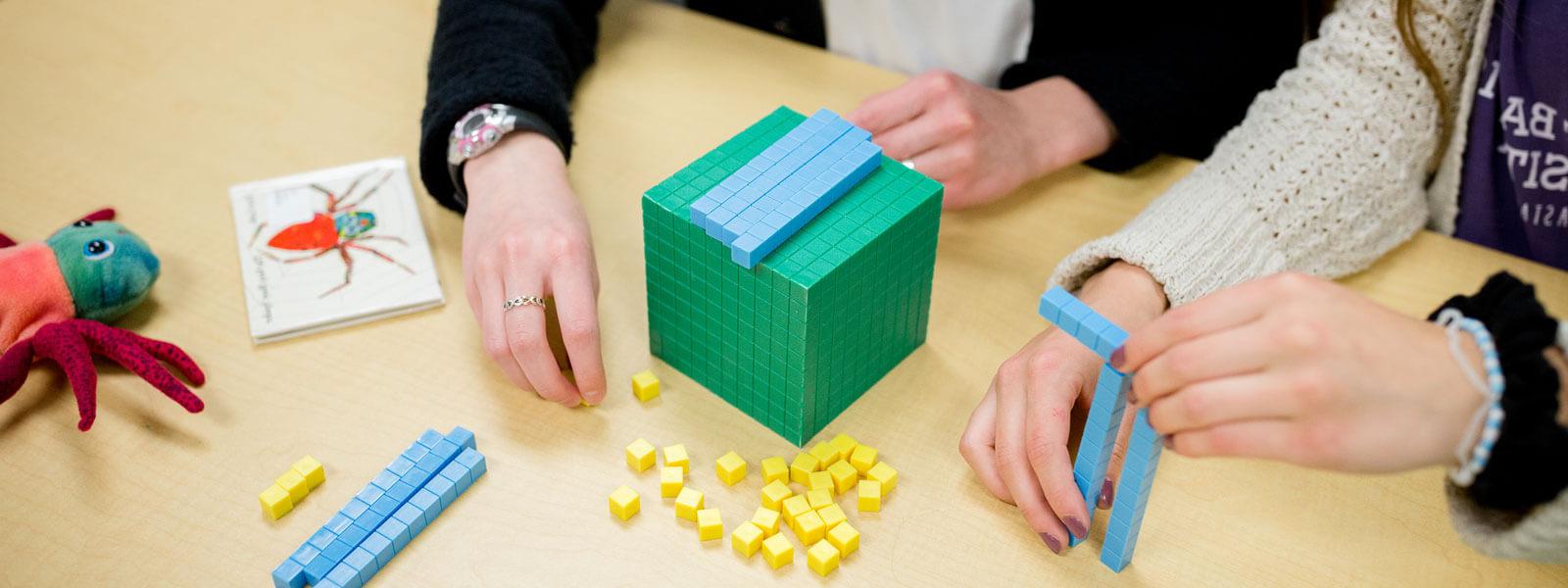 close-up of 学生' hands as they work with math manipulative blocks